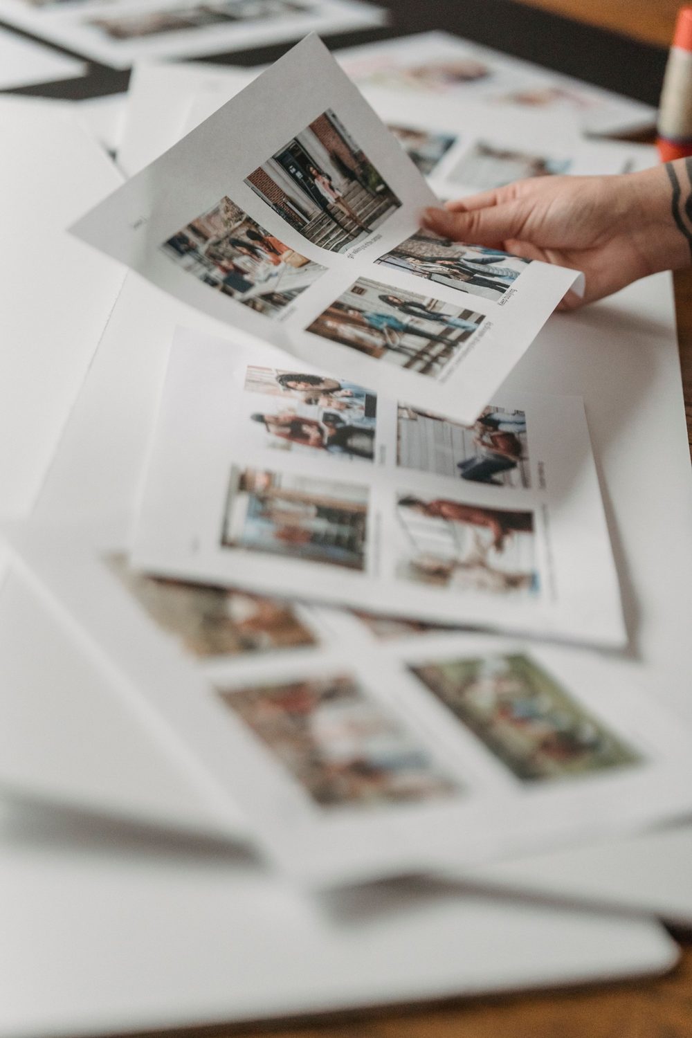 Sheets of photo prints being looked through by hand